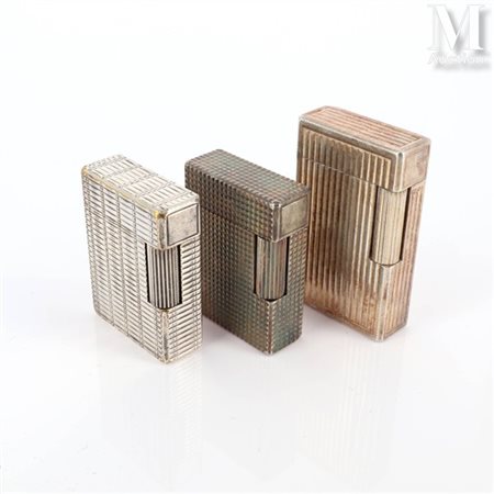S.T. DUPONT Trois briquets Dupont en métal argenté à décor divers. Signés et...
