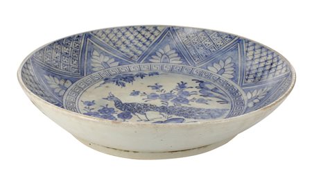 Cina. XIX secolo
Grande piatto con decoro di pavone tra fiori e rocce