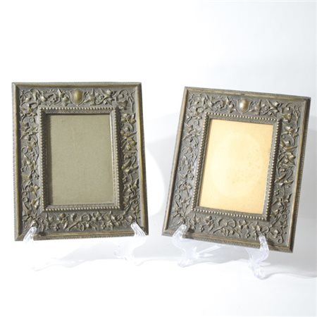 Coppia di cornici rettangolari in metallo argentato e sbalzato a tralci...