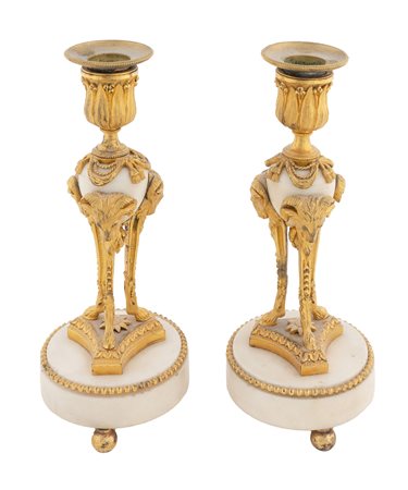 Francia inizio XIX secolo, Coppia di candelabri in bronzo dorato su base a tripode con teste di ariete. 