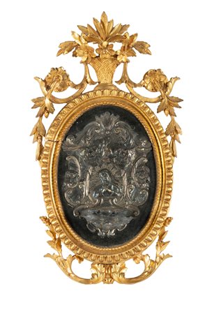 Italia, prima metà XIX secolo, Acquasantiera in argento a sbalzo entro cornice intagliata e dorata. 