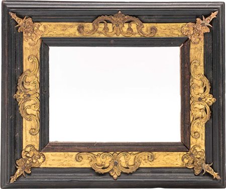 Cornice in legno ebanizzato con finiture ornamentali in rame e bronzo dorati,...
