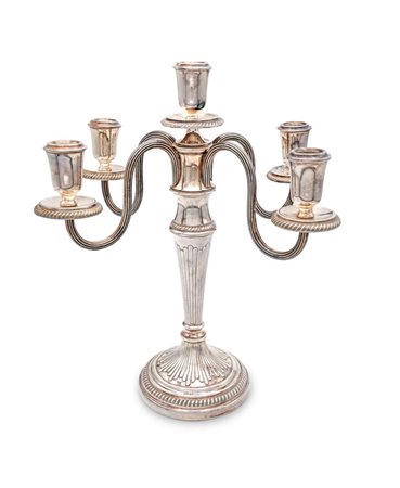 Candelabro in argento 800/000 a cinque luci fusto rastremato da cui si...