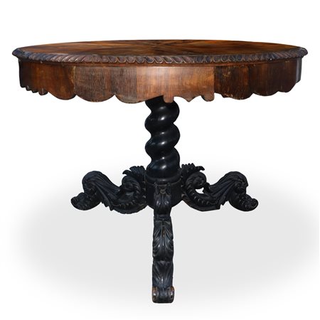 Tavolo rotondo con piano  dentellato al bordo piede a tre  razze scolpito e intagliato in legno  di palissandro