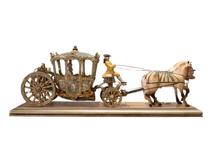 Luigi Fabris (Bassano del Grappa, 1883 - 1952) 
Grande scultura in porcellana policroma raffigurante Dama in una carrozza, cocchiere e due cavalli. 
 cm 102x32x38; dimensioni della base lignea dorata cm 110x34,5