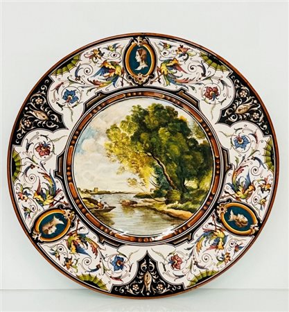 Manifattura Faventia Ars dei Fratelli Castellini, Faenza metà del XX secolo  
Piatto in ceramica con paesaggio fluviale nel cavetto e grottesche alla tesa 
 diametro cm 42