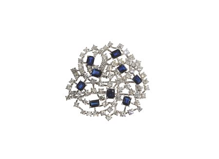  - Spilla in oro bianco 18k con diamanti bianchi  taglio a brillante 5.25 ct. stimati e zaffiri blu carré 5.25 ct. Fasoli Brescia.