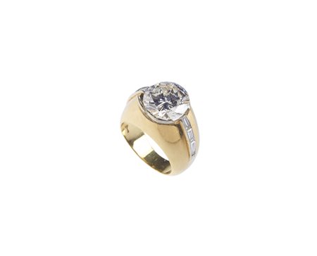  - Anello a fascia in oro giallo 18kt,  con diamante taglio a brillante e baguette laterali.