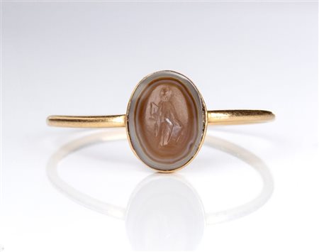 A small Roman agate intaglio set in a later gold ring. Fortuna-Tyche.