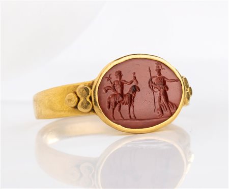 A Roman gold ring set with a red jasper intaglio. Hermes and Athena.