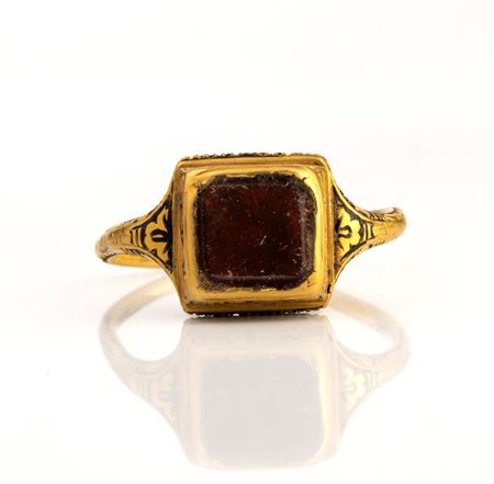 A Late Renaissanace gold and black enamel ring set with a garnet.