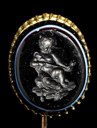A dark glass paste impression set in a gold stick pin. Hercules as a child killing the snakes