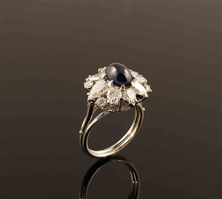 Anello in platino con al centro incastonato uno zaffiro cabochon per carati...