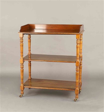 Etagere in mogano a tre ripiani sorretti da colonnine tornite, provvisto di...