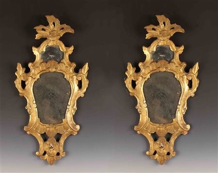 Coppia di specchierine in legno dorato ed intagliato, cornice sagomata e...