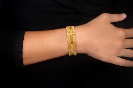 Bracciale in oro giallo 750 a tre maglie semirigido intersecato da barrette in oro