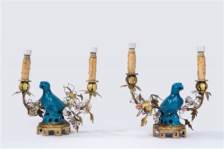 Coppia di candelabri a due luci in metallo decorati da pappagalli e fiori policromi