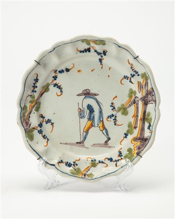 Piatto in maiolica con profilo sagomato e profilato in blu di cobalto decorato in policromia a gran fuoco con viandante in un paesaggio, Manifattura di Savona, secolo XVIII