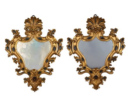 Coppia di specchiere di forma mossa in legno intagliato, dorato e dipinto a volute fogliate, cimasa a palmetta, secolo XIX