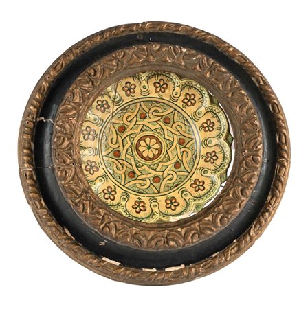 () Piatto in ceramica smaltata entro cornice rotonda Al verso reca monogramma...