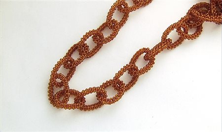 COLLANA COLLANA. Ad un lungo filo di motivi ovali realizzati in microsfere di...