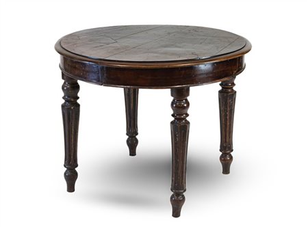 Tavolo con piano circolare impiallacciato in noce, gambe tornite e scanalate. S