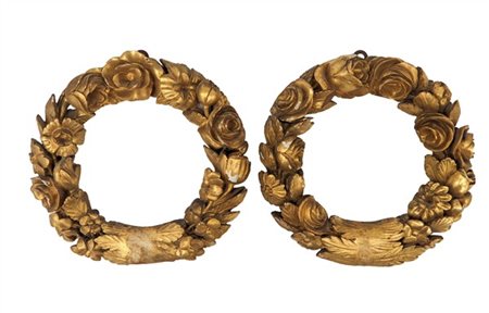 Coppia di fregi circolari in legno intagliato e dorato a foglie, fiori e rose.