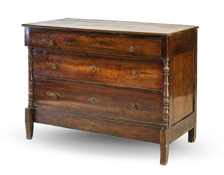 Comò in noce a tre cassetti sul fronte con montanti a semicolonna tornita, pied