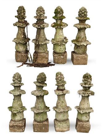 Gruppo di otto pilastrini da giardino sagomati a foglie con cimatura a pigna. I