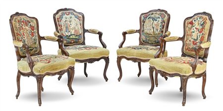 Gruppo di quattro poltrone in noce intagliato e tinto a foglie e fiori con brac