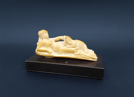 Scultura raffigurante un nudo femminile sdraiato con cocker spaniel in dente di