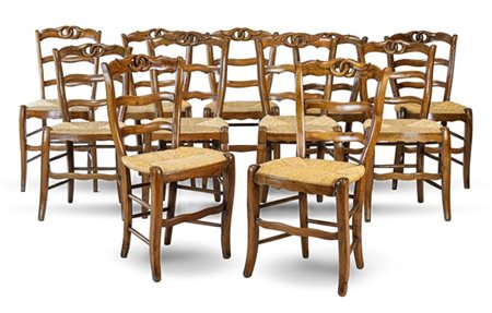 Gruppo di undici sedie in legni vari con schienale a giorno e cimasa traforata,