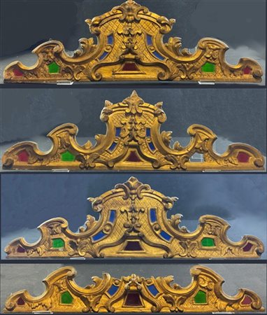 Gruppo di quattro fregi in legno intagliato e dorato con decori a volute. Secol