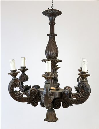 Lampadario in legno intagliato e tinto a sette luci con bracci a voluta contrap