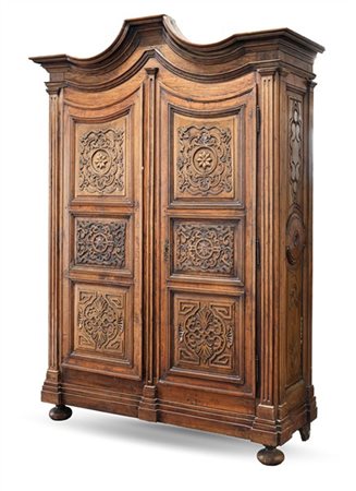 Armadio in legni vari a due ante sagomate con antiche pannellature intagliate a