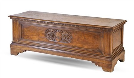 Cassapanca in noce con fronte decorato da intaglio a scudo araldico fra volute,