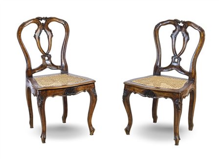 Coppia di sedie da balia di forma mossa in noce intagliato con schienali a gior