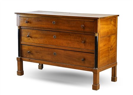 Cassettone in noce a tre cassetti tra semi colonne ebanizzate su piedi a plinto