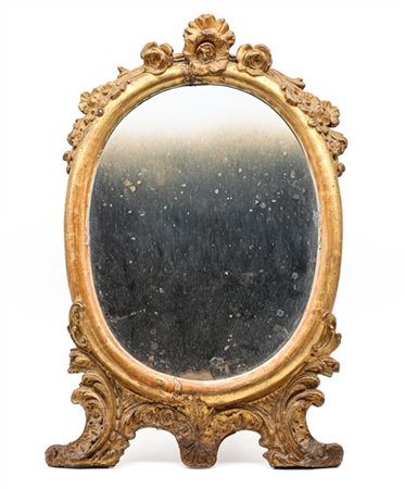 Specchiera d'appoggio di forma ovale in legno e pastiglia dorati con cimasa a f