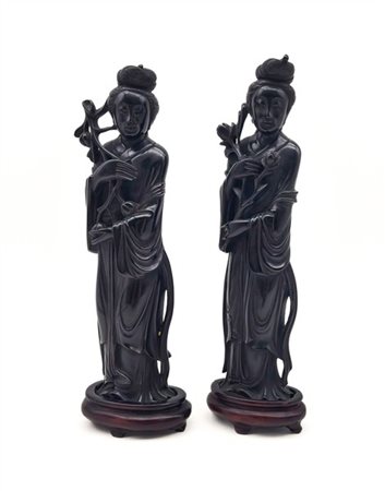 Coppia di dame dalle lunghe vesti in bachelite scura. Raffigurate con capelli a