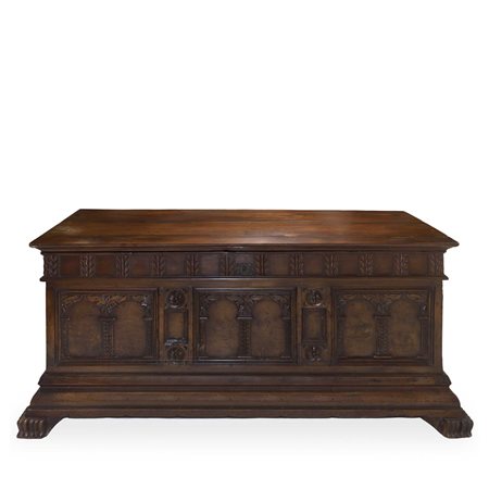 Cassapanca in noce scolpita e intagliata sul fronte con colonne ed archi, piedi felini e cornice bassa aggettante, 18° secolo