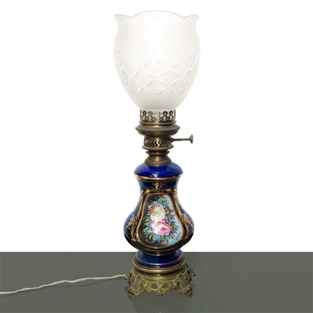 Lume in porcellana blu con fiori policromi dipinti sul fronte entro ovale dorato con diffusore in vetro intagliato