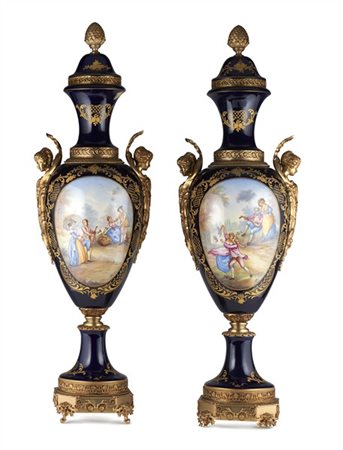 Manifattura francese, secolo XX. Coppia di vasi ad anfora in porcellana dipinta