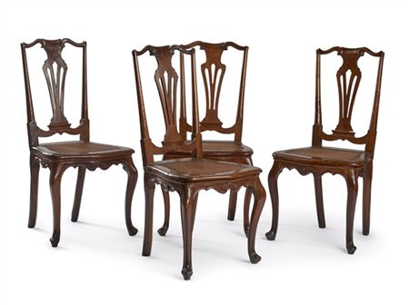 Gruppo di quattro sedie in noce con schienale a giorno decorato a volute con ca