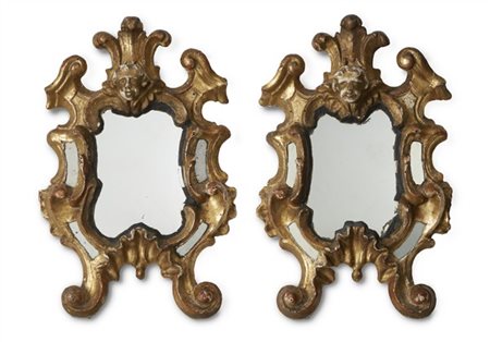 Coppia di specchierine di forma sagomata in legno intagliato e dorato a volute