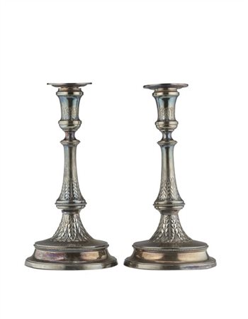Coppia di candelieri in argento con profili perlinati, fusto e base circolare d