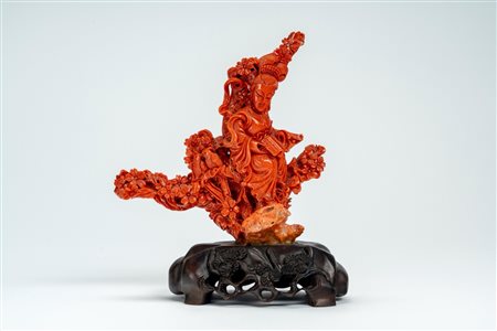 ☼ Scultura in corallo finemente intagliato raffigurante dama reggente un libro, appoggiata su tronco fiorito con uccellini, su base lignea intagliata e traforata. Cina, inizio secolo XX
