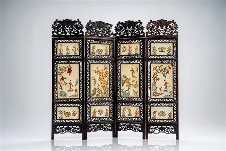 Paravento da tavolo a quattro ante in legno traforato, con pannelli in pietra dura decorati a rilievo con figure e motivi floreali policromi. Cina, inizi secolo XX