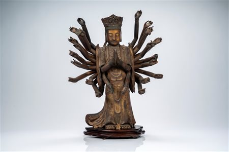 Grande figura stante in legno intagliato, laccato e dorato, raffigurante Guanyin dalle Mille Braccia, su base lignea di epoca successiva. Cina, secolo XVII