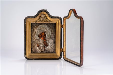 Icona a tempera su tavola con cornice lignea dorata e riza in argento raffigurante la Madonna di Vladimir, entro teca coeva in legno con anta apribile […]